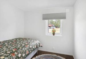 a bedroom with a bed and a window at Newly Built House with Free Parking in Scenic Nature in Umeå