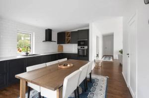 a kitchen and dining room with a wooden table at Newly Built House with Free Parking in Scenic Nature in Umeå
