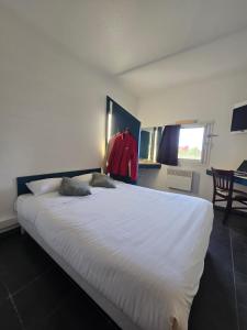 a large white bed in a room with a window at Enzo Hotels 1er prix Dreux in Dreux +2 photos