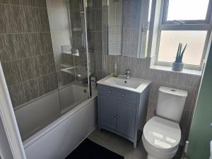 a bathroom with a toilet and a shower and a sink at Cozy Home in Aylesbury Buckinghamshire in Bierton +8 photos
