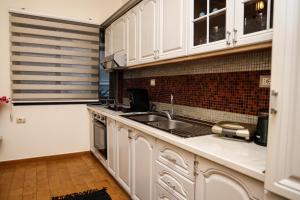 a kitchen with white cabinets and a sink at Villa Baja in Kamëz