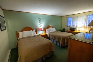 a hotel room with two beds in a room at Jimmy OConnor's Windham Mtn Inn in Windham