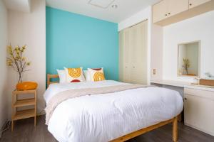a bedroom with a bed and a blue wall at ダイナスティパレス58 in Sapporo