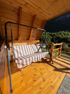 a swing on the porch of a roof at A&R cottages in Vusanje +31 photos