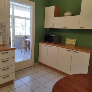 Una cocina con gabinetes blancos y una mesa. en Maison de plein pied et tranquille, en Sanguinet