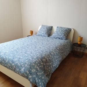 Un dormitorio con una cama con un edredón azul. en Maison de plein pied et tranquille, en Sanguinet