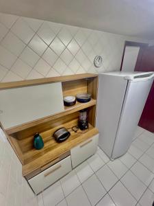 a small kitchen with a white refrigerator in a room at Cantinho na praia in Arraial do Cabo