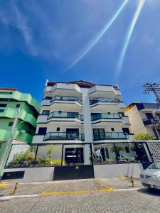 a tall apartment building with a rainbow in the sky at Cantinho na praia in Arraial do Cabo