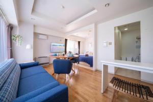 a living room with a blue couch and a table at ダイナスティパレス58 in Sapporo