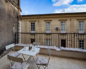 a white table and chairs on a balcony with a building at Stanza Libera in Venafro