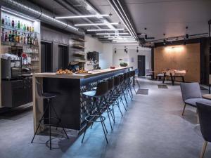 a bar in a room with stools and a counter at ibis Styles Bâle-Mulhouse Aéroport in Blotzheim