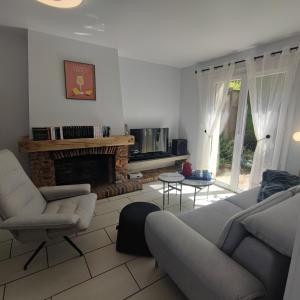 a living room with a couch and a fireplace at Au Coeur du Verger in Thiescourt