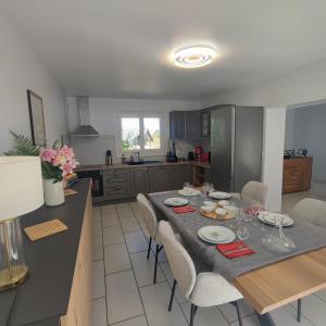 a kitchen with a table and chairs in a kitchen at Au Coeur du Verger in Thiescourt