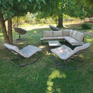 three chairs and a couch and a table in the grass at Au Coeur du Verger in Thiescourt +4 photos