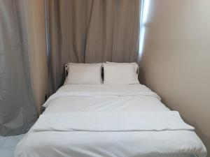 a bed with white sheets and pillows in a room at Portia Beach Grand in Hulhumale