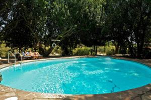 a large blue swimming pool with people sitting in chairs around it at Mara Intrepids Tented Camp in Talek