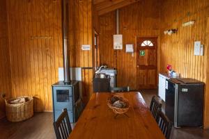 a kitchen with a wooden table and a stove at Cabañas El Maiten in Puerto Guadal
