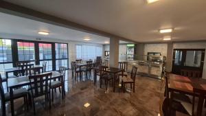a restaurant with wooden tables and chairs and a kitchen at Casa Medeea in Podu Turcului