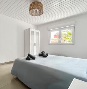 Cama grande en habitación blanca con techo en Parking privé & terrasse ensoleillée, en Illzach