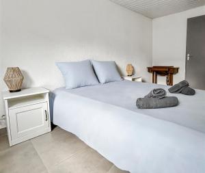 Un dormitorio con una gran cama blanca y una mesa. en Parking privé & terrasse ensoleillée, en Illzach