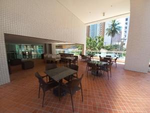 a restaurant with tables and chairs in a building at Beach Class Fortaleza in Fortaleza