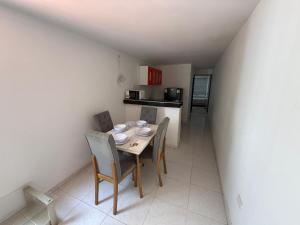 a dining room with a table and chairs and a kitchen at Apartamento Montecristo in Barranquilla