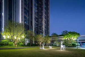 a park with giraffe statues in front of a building at Guangzhou Parker Cloud Residence in Guangzhou