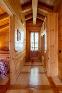 una camera da letto in stile baita di tronchi con letto e finestra di Chalet Il Cerbiatto a Varzo