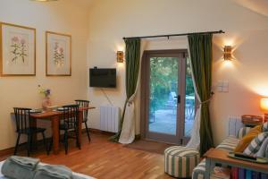 Una televisión o centro de entretenimiento en Wisteria Lodge - Stylish Countryside Lodge on 25-Acre Estate