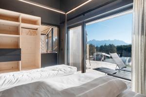 a bedroom with a bed and a large window at Dolomites View X Lodges - Camping in Nova Ponente