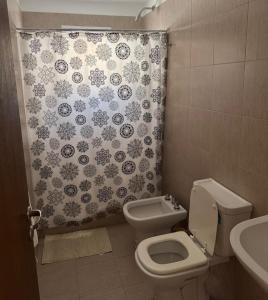 un bagno con un water e una tenda da doccia di CentroTrelew a Trelew
