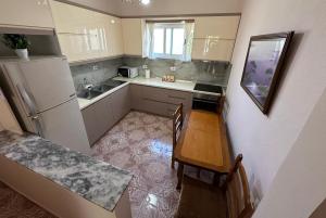 a small kitchen with a table and a refrigerator at Canka Guest House in Përmet