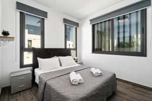 ein Schlafzimmer mit einem Bett mit zwei Handtüchern darauf in der Unterkunft Villa Alassia 16 by Ezoria Villas in Paralimni + 27 Fotos