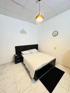 a bedroom with a bed and a clock on the wall at Résidence Océane in Godomey