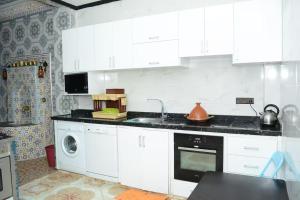 メクネスにあるMeknès 1 Royal Suitesのキッチン(白いキャビネット、洗濯機付)
