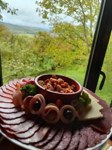 a plate of food with a bowl of meat and cheese at Ur Njam-Njam in Vrnjačka Banja