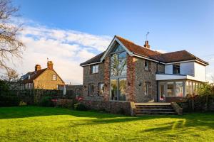 a large brick house with a green yard at Vine Cottage in Blakeney