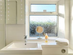 a white bathroom with a sink and a window at 2 Bed in Thornicombe 90161 in Charlton Marshall +7 photos