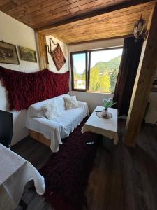 a room with two beds and a table and a window at Mountain Whisper Guesthouse in Smolyan