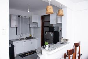 a kitchen with white cabinets and a black refrigerator at Kayla Suites in Busia