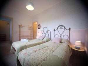Un dormitorio con dos camas y una lámpara. en Historic family house, en Montefiascone