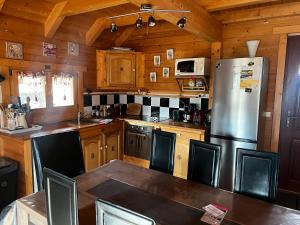 a kitchen with a stainless steel refrigerator and wooden cabinets at Chalet de Lucie et Lison in Erckartswiller