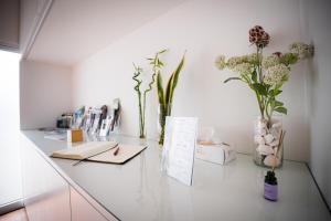 a glass counter with flowers and books on it at Terra Vivaz - Ribeira Cottage in Ribeira Grande