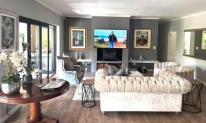 a living room with a couch and a table at 10onErika Franschhoek in Franschhoek