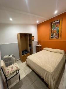 a bedroom with a bed with an orange wall at Departamento in Necochea