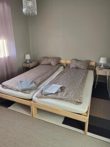 two twin beds in a room with two tables at Sól - S12 Guesthouse in Keflavík