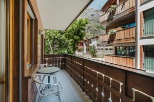 Un balcón con una mesa y un taburete. en Haus Bor, en Zermatt