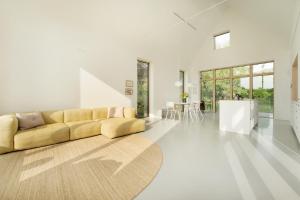 a living room with a yellow couch and a table at Haus am See in Gosdorf