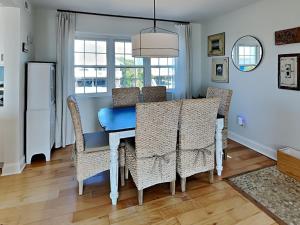 una sala da pranzo con tavolo e sedie blu di Riptide a Sloop Point