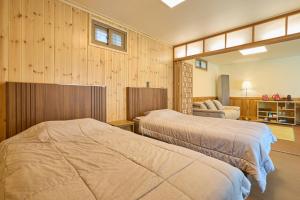 two beds in a room with wooden walls at Andong Hanok Stay Traditonal House 안동별장  +16 photos
